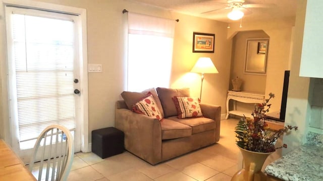 206 Edgewood Dr, West Palm Beach, FL 33405 - living area featuring light tile patterned floors, arched walkways, and a ceiling fan