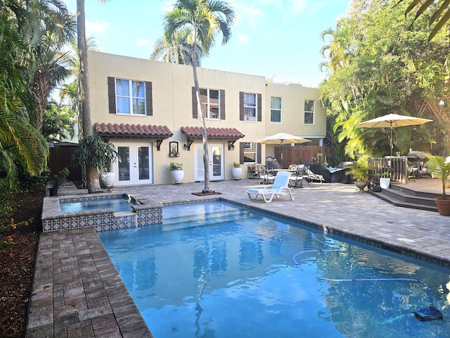 rear view of property with a patio, fence, a tiled roof, french doors, and stucco siding