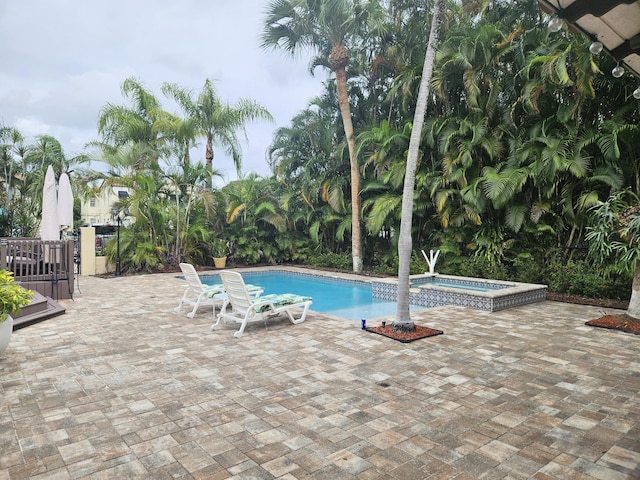 view of pool featuring a patio area and a pool with connected hot tub