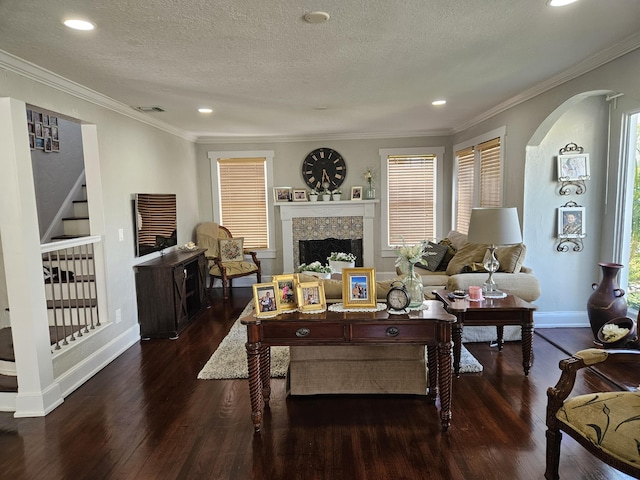 living room featuring a textured ceiling, stairway, a fireplace, and wood finished floors