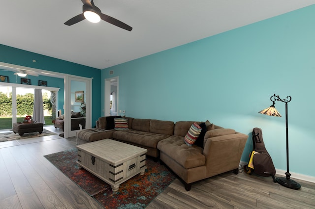 living room featuring a ceiling fan, baseboards, and wood finished floors