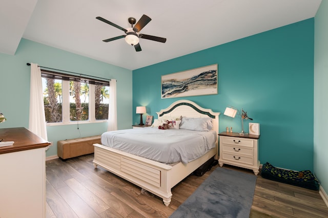 bedroom with baseboards, a ceiling fan, and dark wood-type flooring