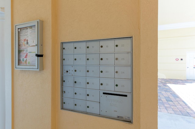 exterior details featuring mail area and stucco siding