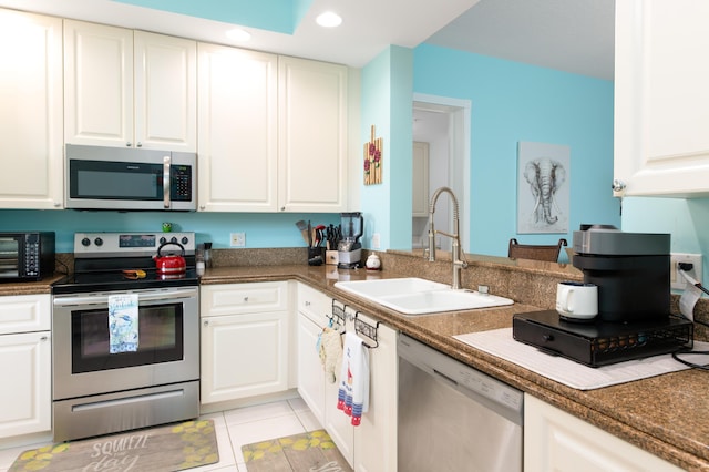 kitchen with appliances with stainless steel finishes, white cabinets, and a sink