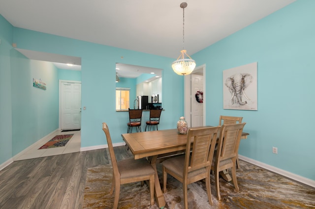 dining area with baseboards and wood finished floors