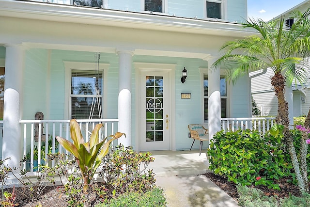 view of exterior entry featuring covered porch