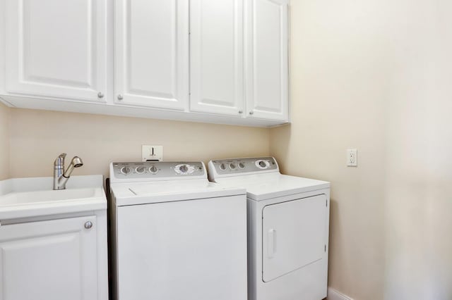 laundry area with cabinet space, a sink, and washing machine and clothes dryer