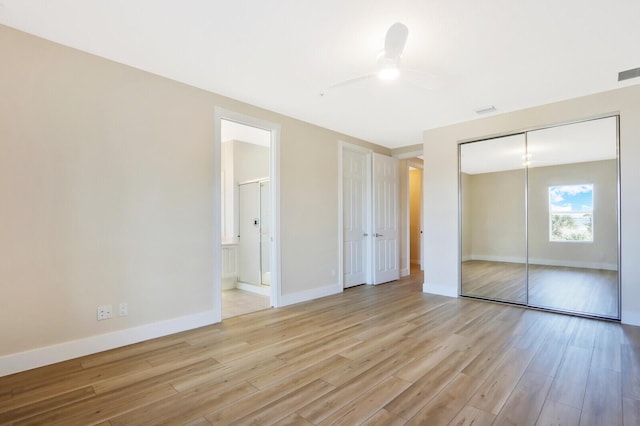 unfurnished bedroom featuring light wood finished floors, a closet, baseboards, and connected bathroom