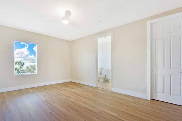 unfurnished bedroom with light wood-style floors, baseboards, a ceiling fan, and ensuite bathroom