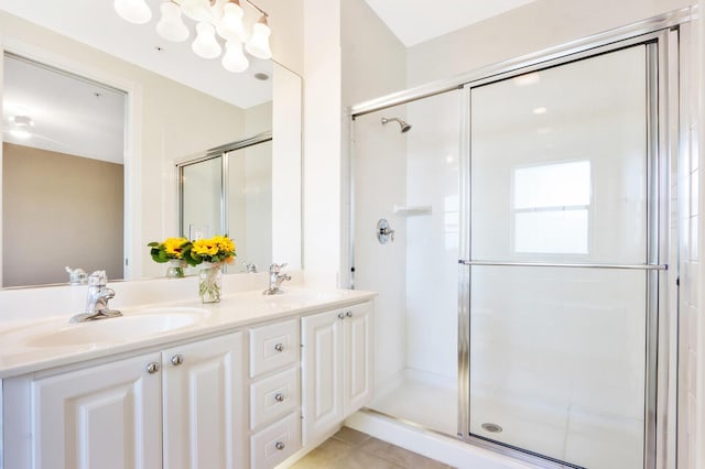 full bath featuring tile patterned flooring, an enclosed shower, a sink, and double vanity