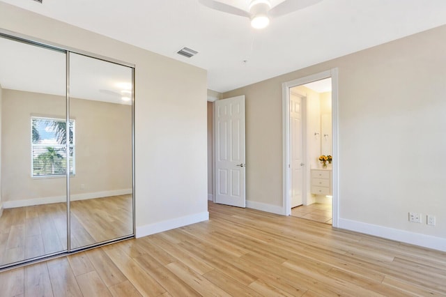 unfurnished bedroom featuring baseboards, visible vents, connected bathroom, light wood-style floors, and a closet