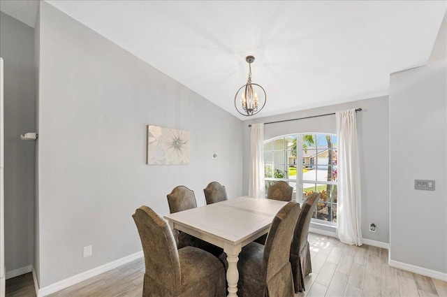 dining area featuring baseboards, an inviting chandelier, vaulted ceiling, french doors, and light wood-style floors