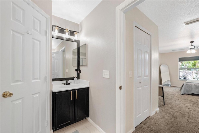 ensuite bathroom with ensuite bathroom, ceiling fan, a textured ceiling, vanity, and a closet