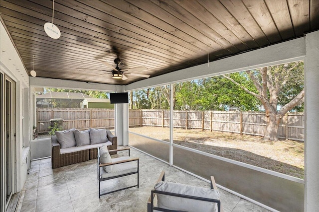 sunroom / solarium with wood ceiling and a ceiling fan