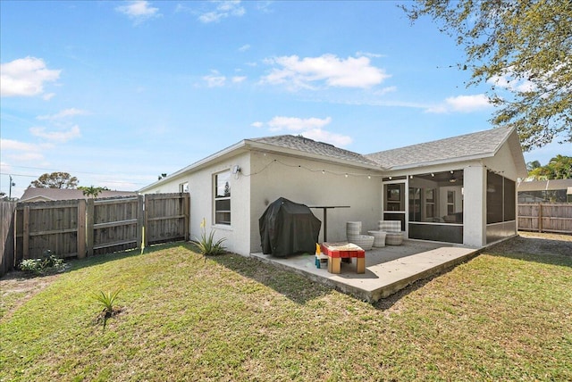 rear view of house featuring a patio, a lawn, a fenced backyard, and a sunroom