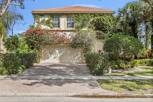 view of front of property with stucco siding, decorative driveway, and a tiled roof