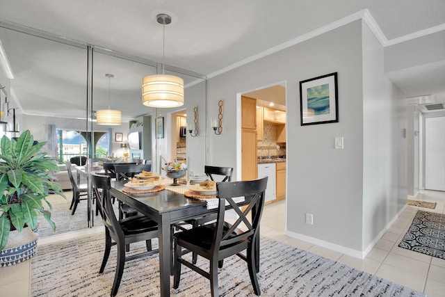 dining room with light tile patterned floors, visible vents, baseboards, and crown molding