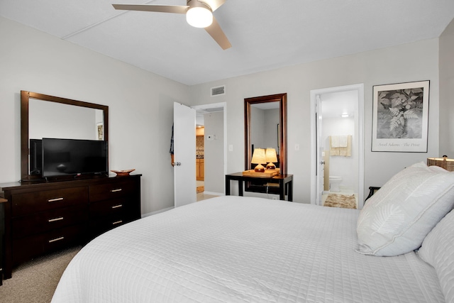 carpeted bedroom with a ceiling fan, visible vents, and connected bathroom