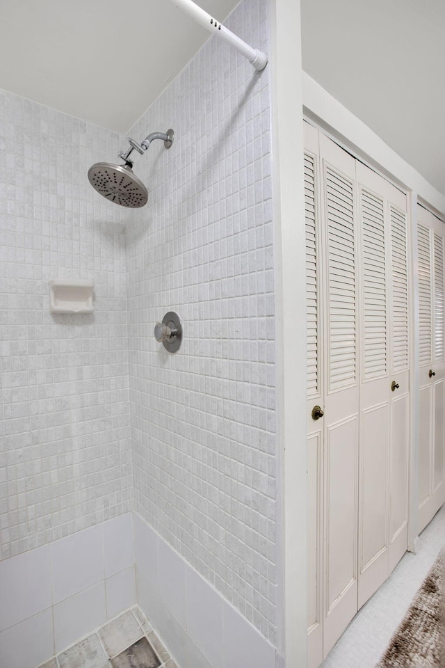 full bath with a closet and tiled shower