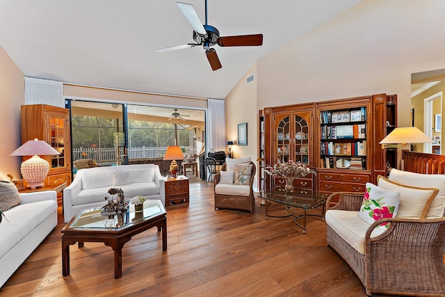 living room with visible vents, high vaulted ceiling, wood finished floors, and a ceiling fan