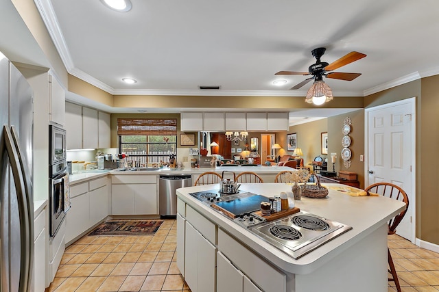 kitchen featuring white cabinets, a breakfast bar area, stainless steel appliances, light countertops, and light tile patterned flooring