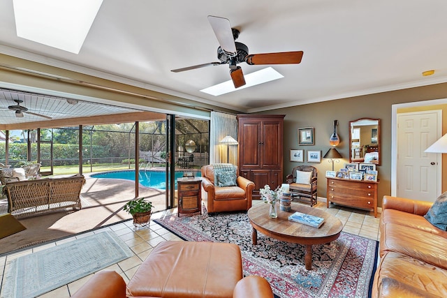 living area with light tile patterned floors, ceiling fan, a skylight, a sunroom, and crown molding