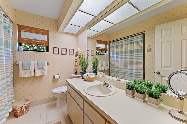 bathroom with toilet, vanity, baseboards, tile patterned floors, and wallpapered walls