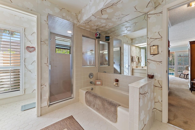 bathroom with a textured ceiling, a garden tub, tile patterned floors, a stall shower, and wallpapered walls