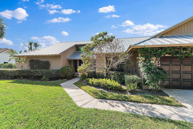 view of front of house featuring a standing seam roof, metal roof, and a front lawn