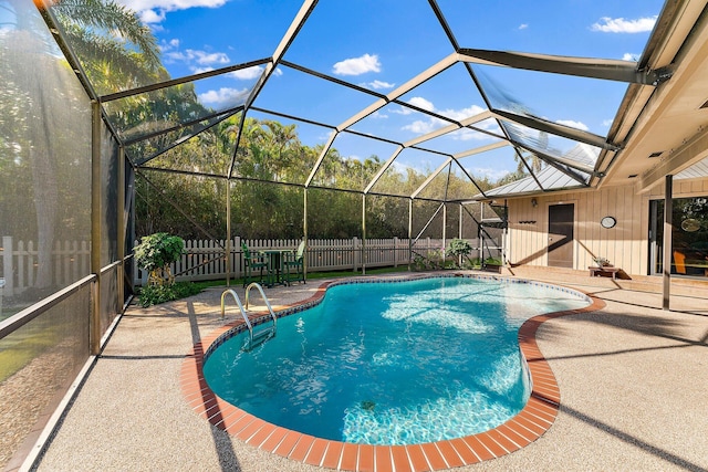 view of swimming pool featuring glass enclosure, a fenced backyard, a fenced in pool, and a patio