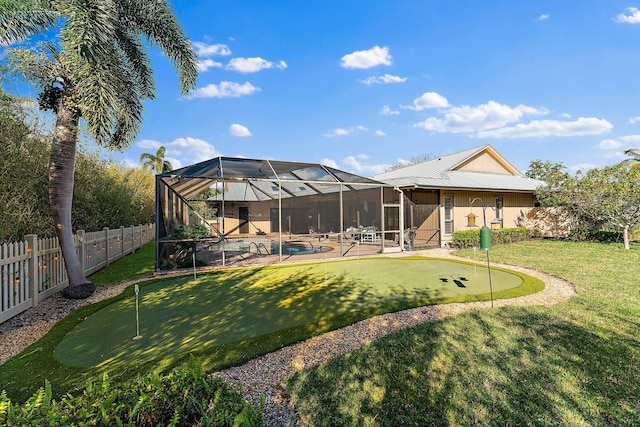 rear view of house featuring metal roof, glass enclosure, a fenced backyard, a fenced in pool, and a patio area