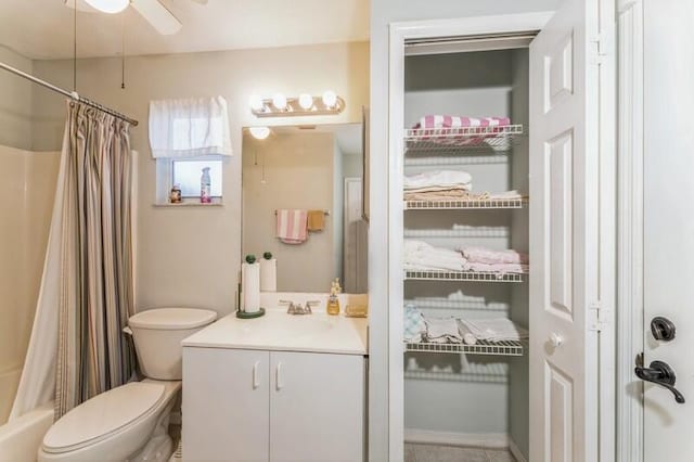 bathroom with toilet, vanity, a ceiling fan, a closet, and shower / bath combo