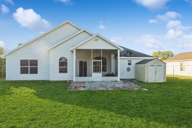 rear view of property with a lawn, an outbuilding, a storage unit, a patio area, and stucco siding