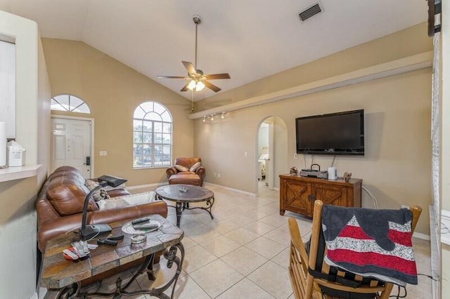 living room featuring arched walkways, ceiling fan, light tile patterned floors, lofted ceiling, and visible vents