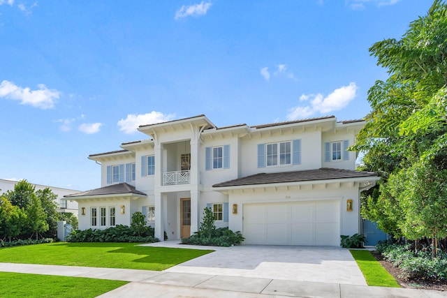 view of front facade with driveway, a garage, a tiled roof, a front yard, and stucco siding