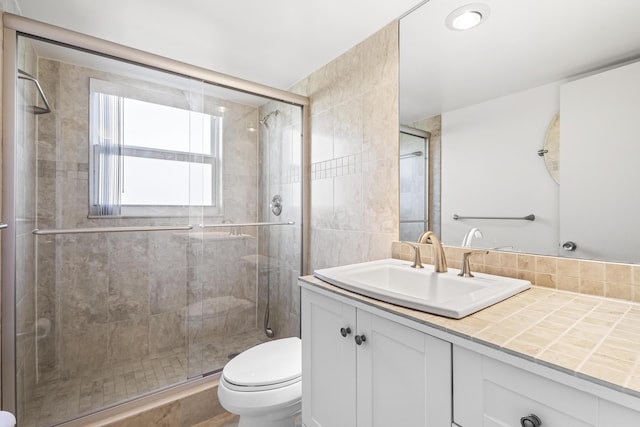 bathroom featuring a shower stall, vanity, and toilet