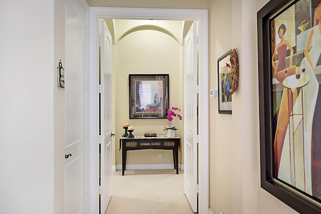 hallway with light carpet and baseboards