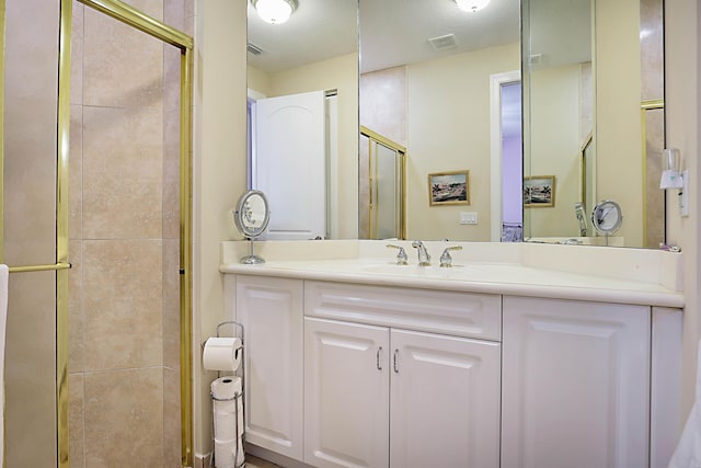 bathroom with visible vents, a shower stall, and vanity