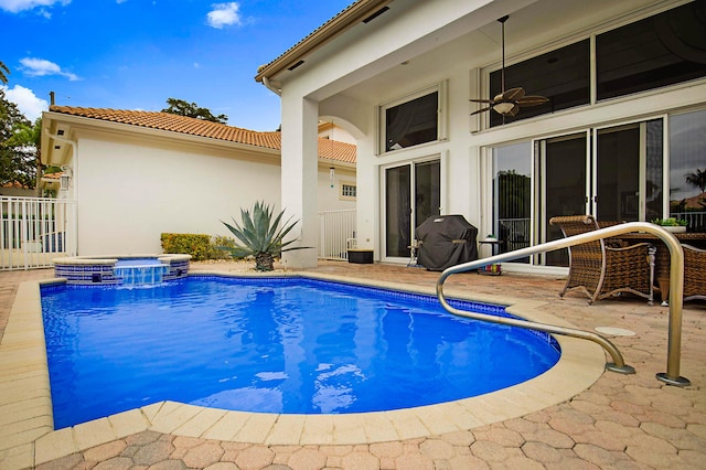 view of swimming pool with a patio, ceiling fan, a grill, fence, and a pool with connected hot tub