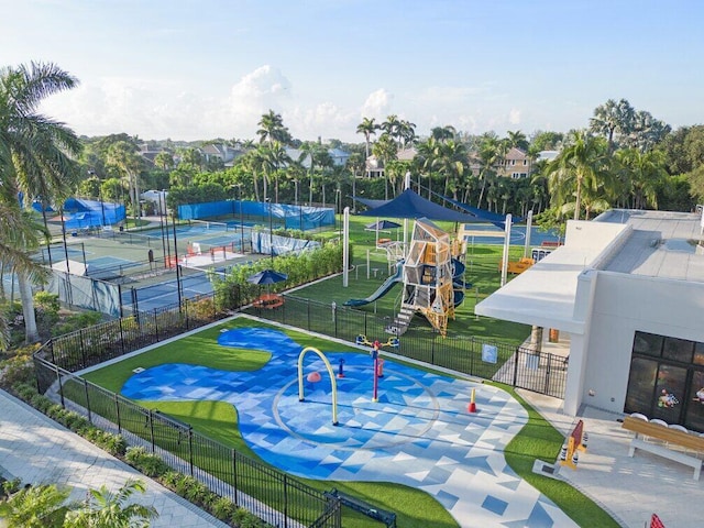 view of community featuring a yard, playground community, and fence