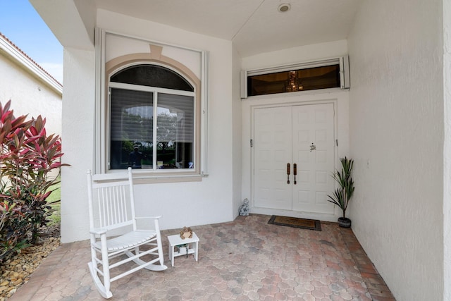 doorway to property featuring stucco siding