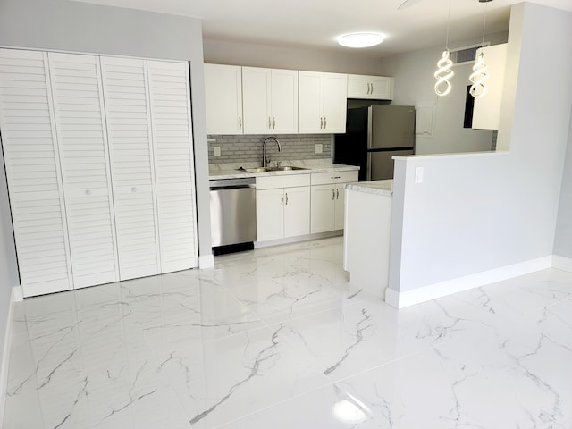 kitchen featuring a sink, stainless steel appliances, light countertops, and white cabinets