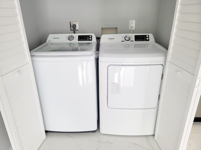 laundry room with laundry area, marble finish floor, and washing machine and clothes dryer