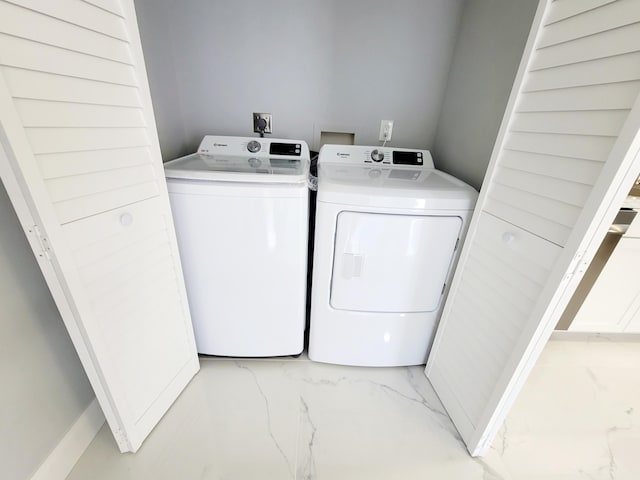 washroom featuring marble finish floor, laundry area, and washer and dryer