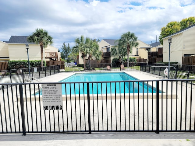 community pool with fence and a residential view