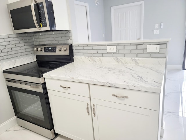 kitchen with stainless steel appliances, white cabinetry, marble finish floor, backsplash, and light stone countertops