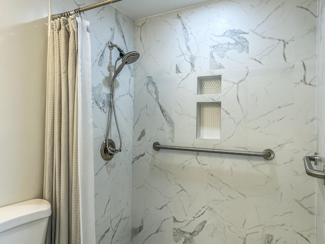 bathroom featuring a marble finish shower and toilet