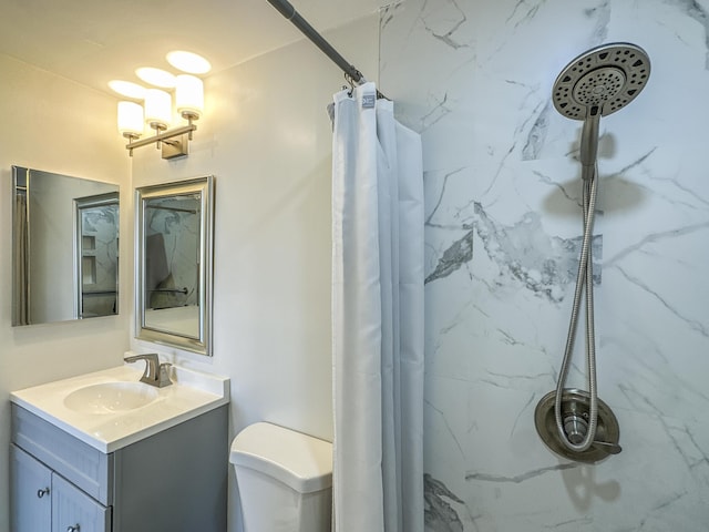 bathroom featuring toilet, vanity, and a marble finish shower