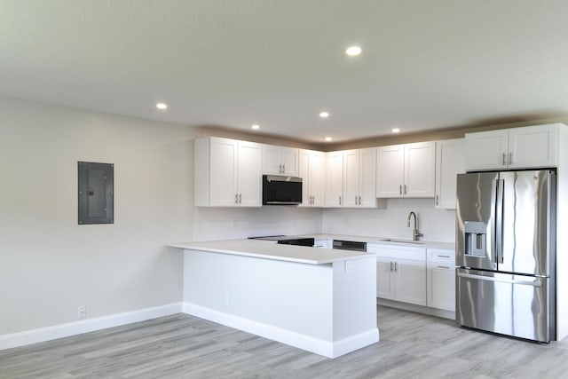 kitchen with electric panel, stainless steel fridge with ice dispenser, a peninsula, light countertops, and a sink