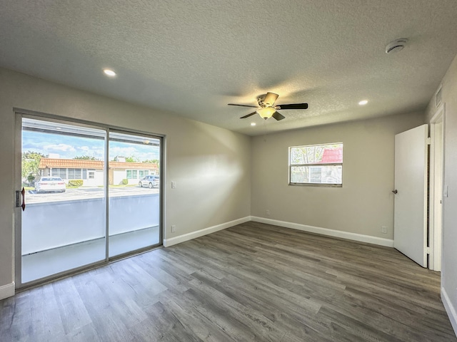 spare room featuring a healthy amount of sunlight, baseboards, and wood finished floors